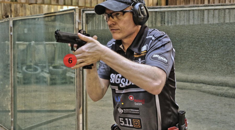 Tecnica di tiro dinamico e IPSC: il cambio del caricatore Tiratore impugna la pistola per mirare
