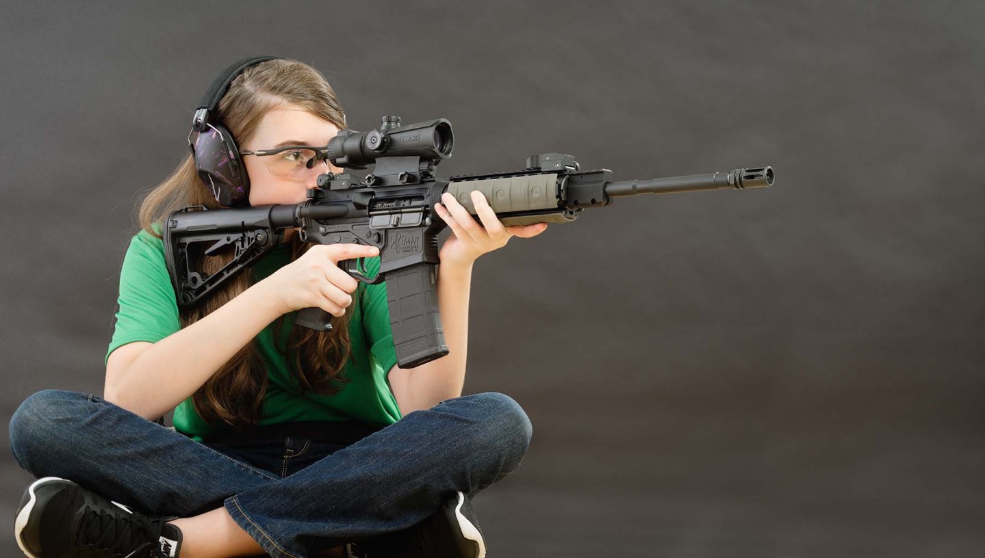 Tiratrice seduta con carabina