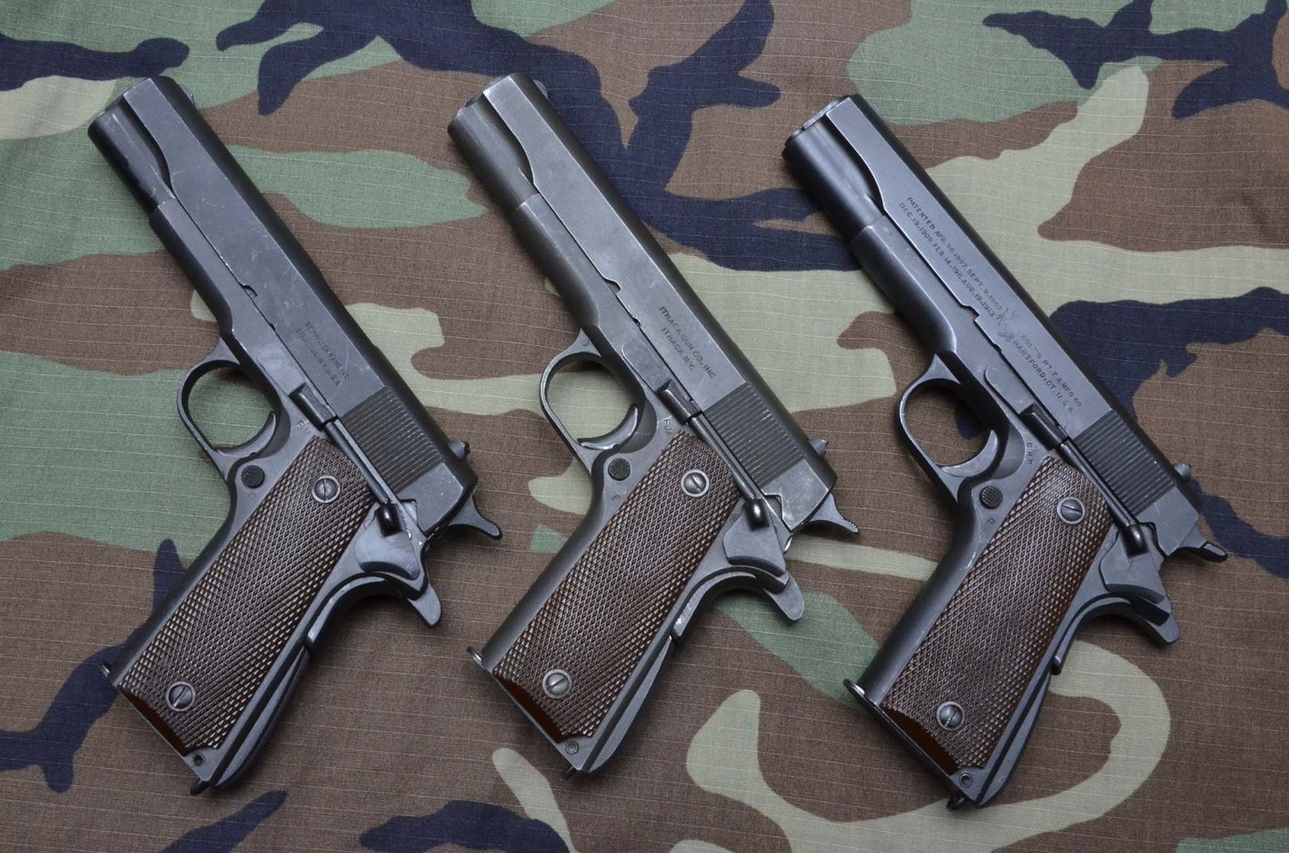 Tre pistole 1911 A1 di produzione bellica. Da sinistra Remington Rand del 1944, Ithaca Gun Co. Del 1944 e Colt del 1943.  