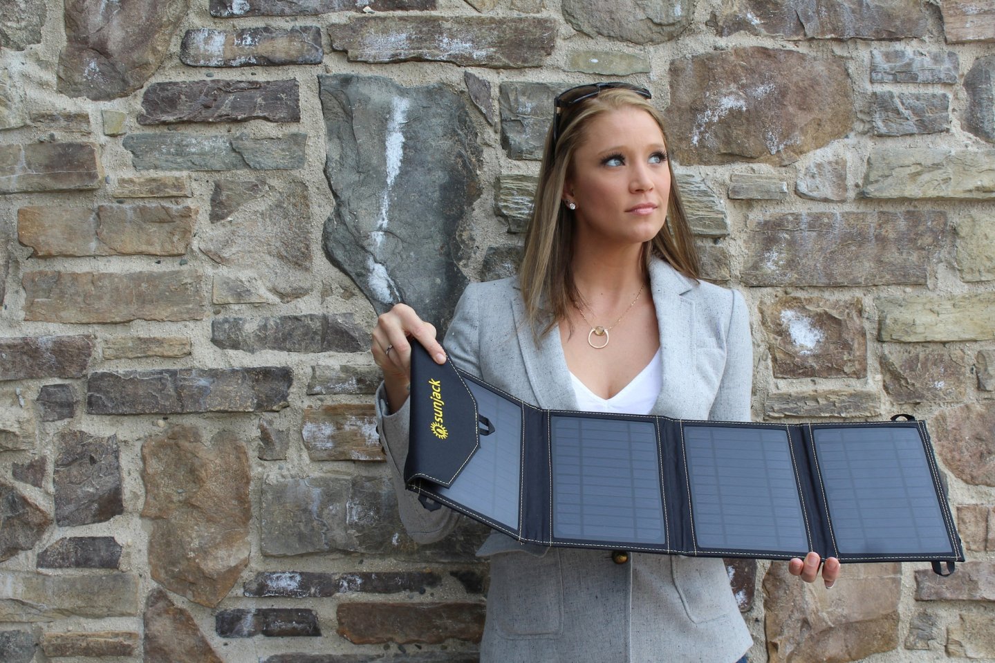 Девушка с портативной солнечной батареей GigaWatt Inc SunJack Solar Charger