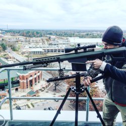 Снайпер с крупнокалиберной снайперской антиматериальной винтовкой Barrett M82, установленной на треножный станок SPEC-REST